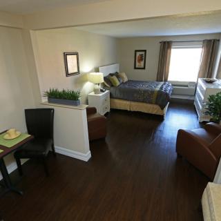 A well-decorated modern bedroom with wooden flooring and comfortable furnishings.