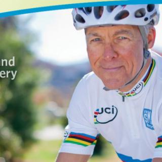 A cyclist wearing a helmet and UCI cycling jersey outdoors.