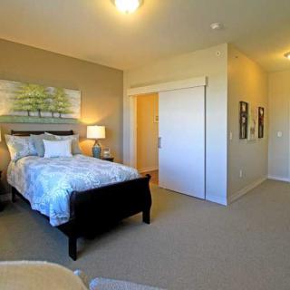 A cozy bedroom with a neatly made bed, warm lighting, and tasteful decor.