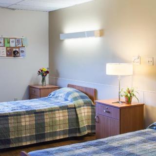 A cozy bedroom with two single beds, wooden furniture, and soft lighting.