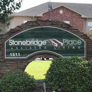 The Stonebridge Place Assisted Living sign in front of a brick building.