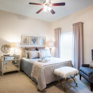 A cozy and elegantly decorated bedroom with a comfortable bed, subtle lighting, and tasteful artwork.