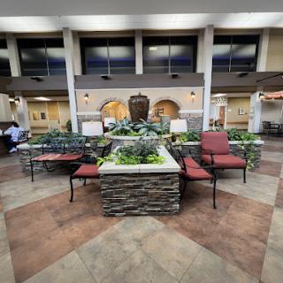 A beautifully designed lobby area featuring a central fountain surrounded by comfortable seating and greenery.