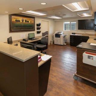 A modern office reception area with desks, computers, and a printer.