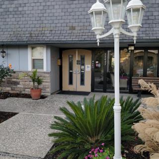 The welcoming entrance of a building, complemented by well-kept landscaping and a charming lamp post.
