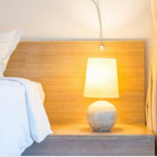 A cozy corner of a modern bedroom featuring a stylish lamp and elegant decor.