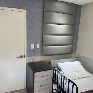 A well-designed hospital room featuring a bed and modern furnishings.