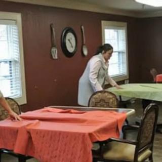 People preparing tables in a dining room.