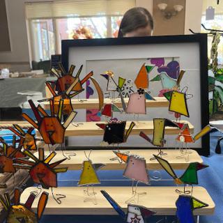 A vibrant display of handcrafted bird figures showcased in a creative arrangement.