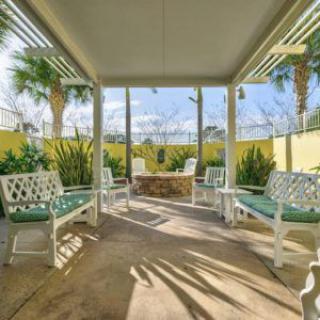 A sunny outdoor patio with benches and lush greenery.