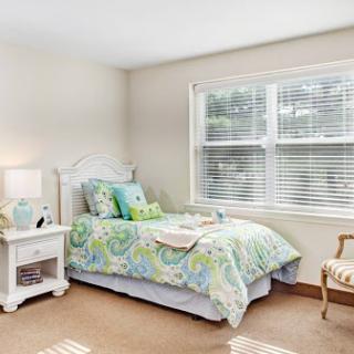 A serene and cozy bedroom featuring soft bedding and natural light.