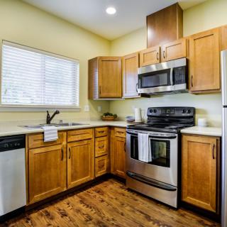 A modern kitchen with wooden cabinets and stainless steel appliances.