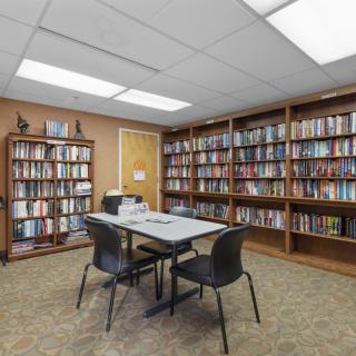 A quiet study area in a library with bookshelves, a table, and chairs.