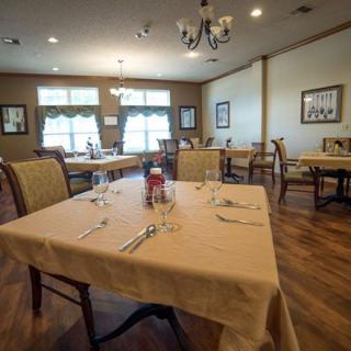 An empty restaurant dining room with tables set for service.