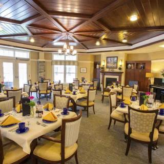 An elegant dining room with neatly arranged tables and chairs, complete with stylish decor and ceiling lights.