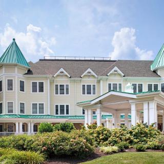 A Victorian-style residential building with green roofs and well-maintained landscaping.
