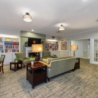 A cozy living room with comfortable seating, bookshelves, and a television.