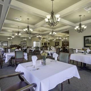 An elegant dining room with white tablecloths and chandeliers.