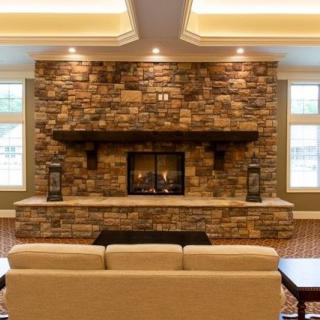 A cozy living room with a stone fireplace and comfortable seating.