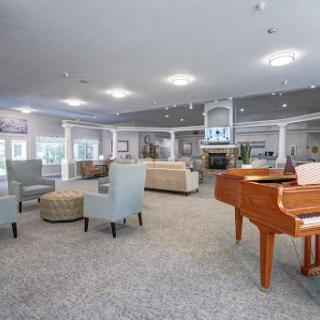 A spacious and inviting lobby featuring comfortable seating arrangements and a grand piano.