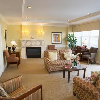 A cozy and elegantly decorated living room with a fireplace, sofas, and warm lighting.