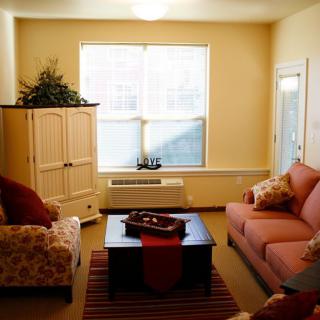 A cozy living room with a sofa, armchair, and coffee table.