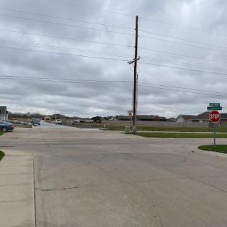 A quiet intersection on a cloudy day, highlighting the suburban landscape.
