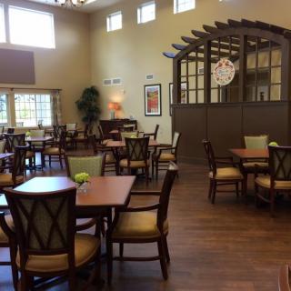 An empty dining room with neatly arranged tables and chairs.