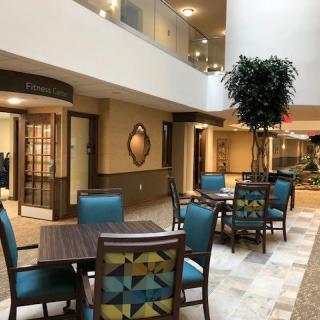A spacious lobby area with tables and chairs, featuring modern design elements and lighting.