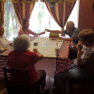 A group of people sitting around a table in a room with natural light coming through the windows.