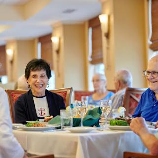 A joyful gathering of seniors enjoying a meal together in a warm and inviting restaurant setting.