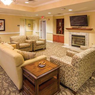 A cozy living room with comfortable seating, a fireplace, and a wall-mounted television.