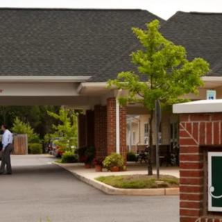 A welcoming entrance to a brick building with landscaping and trees.