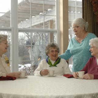 A group of elderly women enjoying a social gathering indoors.
