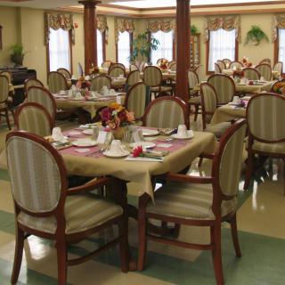 An elegantly set dining room with tables and chairs arranged for guests.