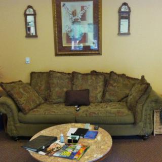 A cozy living room with a green sofa, coffee table, and decorative wall art.