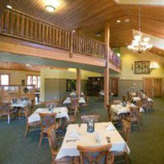 Cozy restaurant interior with neatly arranged tables and warm wooden decor.