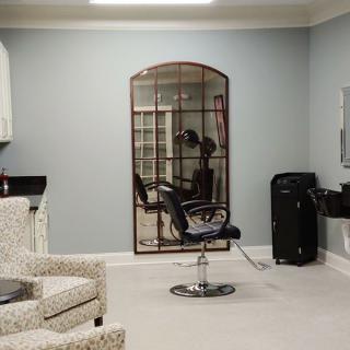 A modern hair salon interior with a styling chair and mirror.
