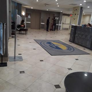 A modern hotel lobby featuring a reception area and elegant flooring.