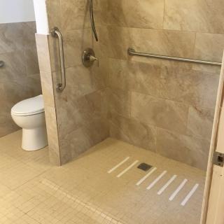 Accessible bathroom with walk-in shower and grab bars.