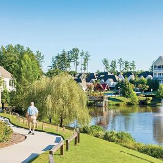 A peaceful lakeside community with lush greenery and walking paths.