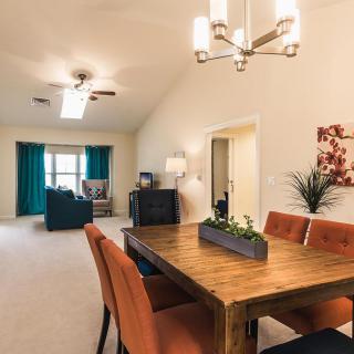 Modern open-plan dining and living area with stylish furniture and bright lighting.