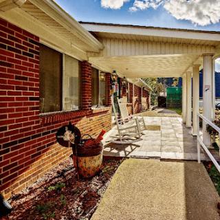 A sunny view of the exterior porch showcasing brickwork and an inviting pathway.