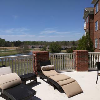 A serene outdoor patio featuring lounge chairs, perfect for enjoying the sunny weather and scenic views.