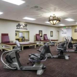 A fitness room with stationary bikes and therapy tables.