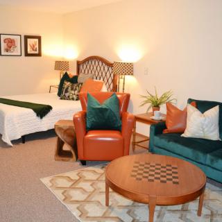 A cozy living room with warm lighting, featuring a sofa and armchair, a wooden coffee table, and stylish decor.
