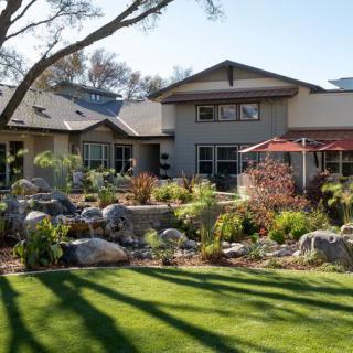 A beautiful house with a lush garden and well-maintained lawn.