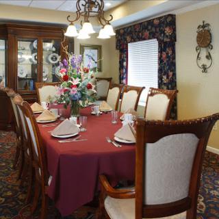 A beautifully arranged dining room featuring an elegant table setting with flowers and a warm ambiance.