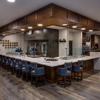 A modern bar interior with wooden accents and ample seating.