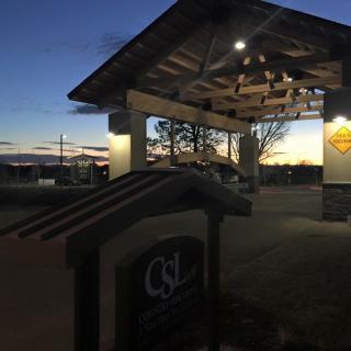A pavilion illuminated at dusk with a scenic sunset backdrop.